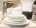 A stack of clean empty white porcelain tableware on a shelf. Kitchenware in the interior of the store or at home.