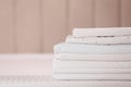 Stack of clean folded linens on bed indoors. Space for text Royalty Free Stock Photo