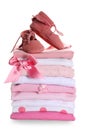 Stack of clean girl`s clothes with booties and bow on white background Royalty Free Stock Photo