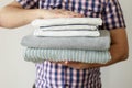 Stack of clean laundered clothes in man hands