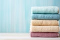 Stack of clean soft colorful bath towels pastel colors on blue background