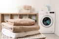 Stack of clean soft towels on basket in laundry room