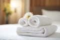 Stack of clean towels with flower on bed in hotel room, closeup, clean white towels on the hotel bed, feels cozy, comfortable and Royalty Free Stock Photo