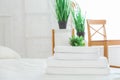 Stack of clean towels on white bed in room. Space for text Royalty Free Stock Photo