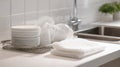 Stack Of Clean White Dishes And Towels On Kitchen Counter. Modern Kitchen Organization And Cleanliness Royalty Free Stock Photo