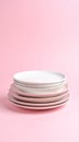 Stack of clean white and pink plates on a pastel pink background Royalty Free Stock Photo