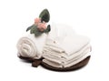 Stack of clean white soft towels with flower on white background - Image Royalty Free Stock Photo