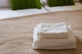 Stack of clean white towels on bed. Cotton soft white towel in hotel Royalty Free Stock Photo