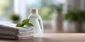 Stack of clean white towels with green leaves and a white plastic bottle of detergent on wooden surface in bright natural light Royalty Free Stock Photo