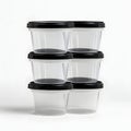 Stack of clear plastic containers with black lids isolated on white background Royalty Free Stock Photo