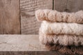 Stack of clothes from knitted knitwear on a wooden background, copy space. Autumn fall winter homely concept.