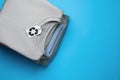 Stack of clothes with recycling label on light blue background, top view. Space for text Royalty Free Stock Photo