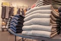 A stack of clothes in the store, pullovers and sweatshirts nicely and neatly stacked in bundles on the table, beige and Royalty Free Stock Photo