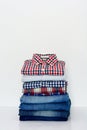 Stack of plaid shirts and jeans on white background Royalty Free Stock Photo