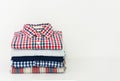 Stack of plaid shirts on white background