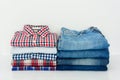 Stack of plaid shirts and jeans on white background Royalty Free Stock Photo