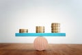 Stack of coins balance on seesaw Royalty Free Stock Photo