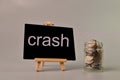 Stack of coins and chalkboard written with CRASH