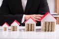 Coins And Different Sizes House Model Front Of Businessman Royalty Free Stock Photo