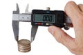 Stack of coins measured with a caliper in mans hand Royalty Free Stock Photo