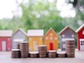 Stack of coins with miniature house background. The concept of saving money for house, Property investment, House mortgage, Real Royalty Free Stock Photo