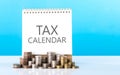 Stack of coins next to a calendar labeled \'TAX.\' Represents the concept of planning and preparing for tax payments Royalty Free Stock Photo
