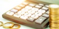 Stack of coins at outdated calculator and euros on table