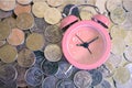 Stack of coins with pink fashioned alarm clock for display planning money financial and business accounting concept