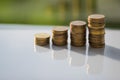 Stack of coins with reflections on the white table Royalty Free Stock Photo