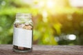 Stack of coins in saving money jar with note paper isolated on n Royalty Free Stock Photo