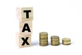 Stack of coins and wooden cubes written with word TAX Royalty Free Stock Photo