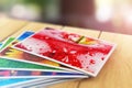 Stack of color photo pictures on wooden table outdoors