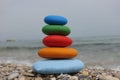 Stack of colored sea stones on a beach and sea background