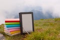 Stack of colorful books and electronic book reader Royalty Free Stock Photo