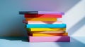 A stack of colorful books with varied hues cast in shadow and light on a soft gradient background Royalty Free Stock Photo