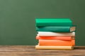 Stack of colorful books on wooden surface Royalty Free Stock Photo