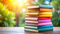 Stack of colorful books on a wooden table with blurred green background. Royalty Free Stock Photo