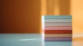 A stack of colorful boxes on a table with sunlight behind them, AI