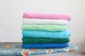 Stack of colorful clean towels  on grey background. Ironing clothes on ironing board. Stack of clean towels on table. Royalty Free Stock Photo