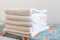 Stack of white clean towels on white background. Ironing clothes on ironing board. Stack of clean towels on table. White towels. Royalty Free Stock Photo