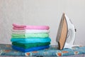 Stack of colorful clean towels on grey background. Ironing clothes on ironing board. Stack of clean towels on table. Royalty Free Stock Photo