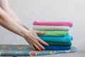 Stack of colorful clean towels  on grey background. Ironing clothes on ironing board. Stack of clean towels on table. Royalty Free Stock Photo