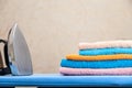 Stack of colorful clean towels on white background. Ironing clothes on ironing board. Stack of clean towels on table. Colored Royalty Free Stock Photo