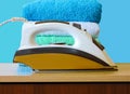 Stack of colorful clean towels  on white background. Ironing clothes on ironing board. Stack of clean towels on table. Colored tow Royalty Free Stock Photo