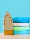 Stack of colorful clean towels  on white background. Ironing clothes on ironing board. Stack of clean towels on table. Colored tow Royalty Free Stock Photo