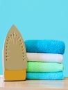 Stack of colorful clean towels  on white background. Ironing clothes on ironing board. Stack of clean towels on table. Colored tow Royalty Free Stock Photo