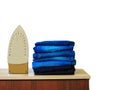 Stack of colorful clean towels  on white background. Ironing clothes on ironing board. Stack of clean towels on table. Colored tow Royalty Free Stock Photo