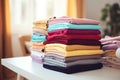 Stack of colorful clothes. Pile of clothing on table. Laundry, household, decluttering, donation, online selling concept