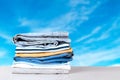 Stack colorful clothes. Pile of folded jeans and cotton shirts on a bright table with space for your display product montage Royalty Free Stock Photo