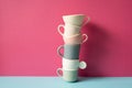 Stack of colorful coffee cups on skyblue table. pink wall background Royalty Free Stock Photo